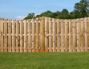 Wood privacy fence with vertical boards installed in a backyard