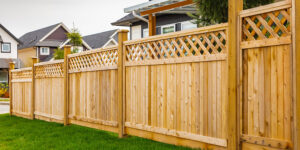Wood privacy fence with lattice topper and posts in a backyard