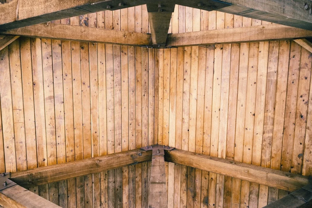 Interior view of a wood roof structure with exposed beams and plank decking.