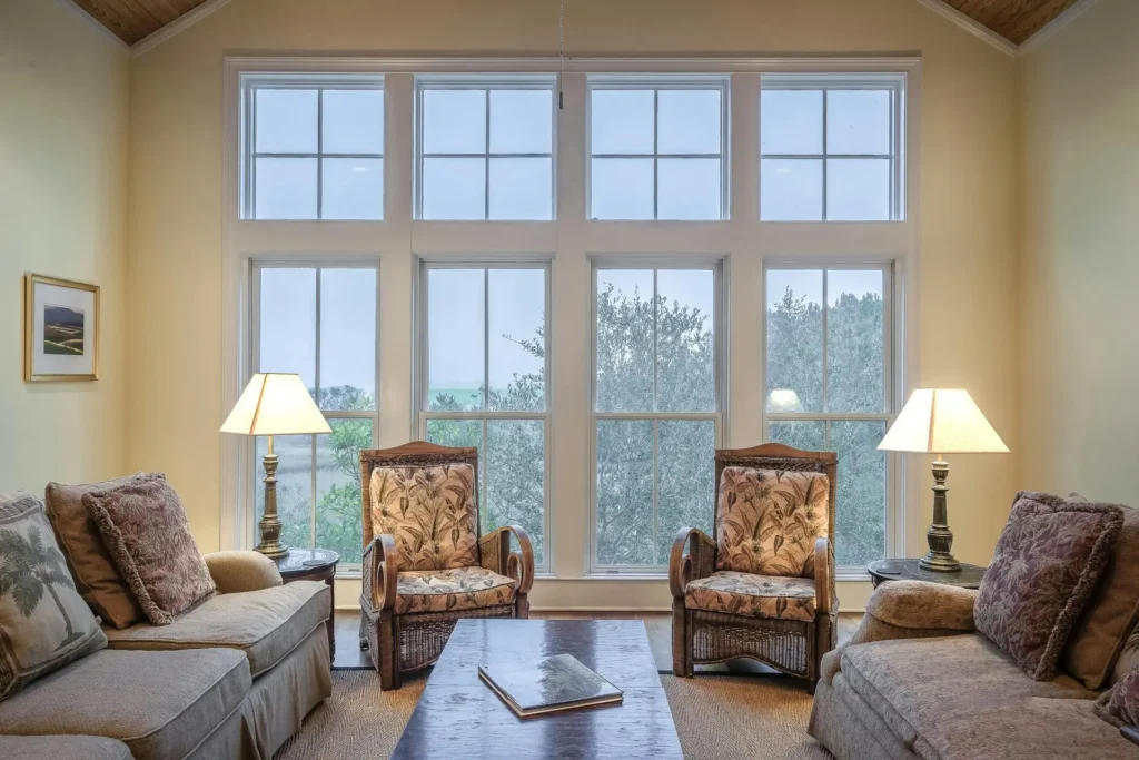 Bright living room with large multi-panel windows allowing natural light and outdoor view